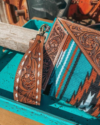 Decorative leather strap with intricate patterns on a turquoise background