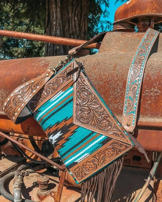 Close-up of a leather and woven purse on a vintage tractor.