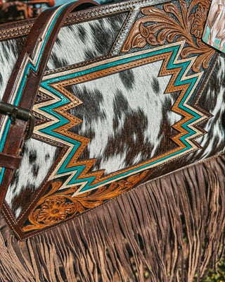 Close-up of a leather bag with cowhide pattern and decorative stitching