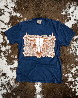 Navy shirt with a tooled western bull skull design on a cowhide rug.