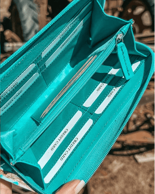 Wallet held by hand on rustic background.