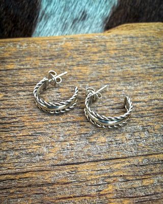 Twined Grace sterling silver half inch hoop earrings by Caroline Tsosie, showing polished center bands and twisted rope edges