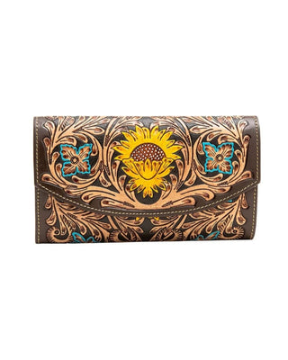 A dark brown tooled leather wallet featuring a large hand-painted yellow sunflower in the center, flanked by turquoise and yellow floral motifs and intricate brown scrollwork.